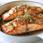 - Salmon fillets - Honey and soy sauce combination - Aromatics: garlic and ginger - Olive oil and seasonings For this honey garlic salmon, you need four salmon fillets. Each fillet should weigh about six ounces. Fresh salmon is best for flavor and texture. Next, gather your sweet and salty mix. You will need a quarter cup of honey and three tablespoons of low-sodium soy sauce. This blend gives the salmon its rich glaze. Now, let's add some flavor. Use four cloves of garlic, minced, and one tablespoon of fresh ginger, grated. These two aromatics make the dish pop with taste. You also need one tablespoon of olive oil. This helps to sear the salmon and adds a nice touch. Add salt and pepper to taste for seasoning. Lastly, consider garnishing your dish. Use one tablespoon of sesame seeds and two chopped green onions. They add a nice crunch and a splash of color to your plate. With these ingredients, you are ready to create a delicious meal that shines with flavor. First, turn on your oven. Set it to 400°F (200°C). This heat helps cook the salmon evenly. Preheating makes sure your fish gets that perfect texture. Grab a small bowl. Add 1/4 cup honey, 3 tablespoons soy sauce, 4 minced garlic cloves, and 1 tablespoon grated ginger. Whisk these together until they blend well. This sauce gives the salmon a sweet and savory taste. Take your large oven-safe skillet. Heat 1 tablespoon of olive oil over medium-high heat. While it heats, season 4 salmon fillets with salt and pepper on both sides. Once the skillet is hot, place the salmon skin-side down. Sear for about 4-5 minutes. You want the skin crispy and golden. Carefully flip the salmon fillets over after searing. Pour the honey garlic sauce over the top of the fish. Now, transfer the skillet to your preheated oven. Bake for 8-10 minutes. The salmon is done when it flakes easily with a fork and reaches 145°F (63°C). Remove the skillet from the oven. Let the salmon rest for a couple of minutes. This step helps the juices stay inside. While it rests, sprinkle sesame seeds and chopped green onions on top for a lovely garnish. Enjoy your beautiful honey garlic salmon! When picking salmon, freshness is key. Look for fillets that are bright and moist. The skin should be shiny and firm. Wild-caught salmon tends to have richer flavor. Farmed salmon is also good but can be milder. Both options work well for this recipe. A hot skillet helps you get a great sear. Start with medium-high heat and add olive oil. Wait until the oil shimmers before adding the salmon. Place the fillets skin-side down and let them cook for 4-5 minutes. Don’t rush this step; a crispy skin adds texture and flavor. You can tweak the sauce to match your taste. If you like it sweeter, add more honey. For a saltier kick, increase the soy sauce. Taste the sauce before pouring it over the salmon. Adjust it so it fits your palate. This way, you create a dish that you truly enjoy. {{image_2}} You can add colorful veggies to your honey garlic salmon. Use bell peppers, broccoli, or asparagus. Chop them into bite-sized pieces. Toss them in olive oil, salt, and pepper. Place the veggies in the skillet with the salmon. Bake them together. The veggies soak up the sauce and taste amazing. This method gives you a complete meal on one pan. Grilling gives the salmon a smoky flavor. Start by marinating the salmon fillets in the honey garlic sauce. Let them soak for at least 30 minutes. Preheat your grill to medium heat. Place the salmon on the grill skin-side down. Grill for about 6-8 minutes per side. Brush more sauce on while grilling for extra flavor. Enjoy the crispy edges and juicy center. Make a large batch of honey garlic sauce for meal prep. Mix honey, soy sauce, garlic, and ginger in a bowl. Use this marinade for other proteins like chicken or tofu. Store the marinade in the fridge for up to a week. Coat your choice of protein before cooking. This makes weeknight dinners quick and easy. Enjoy different meals with the same tasty flavor! To keep your honey garlic salmon fresh, place it in an airtight container. It’s best to store it in the fridge. Make sure to eat it within three days for the best taste. If you want, you can also separate the salmon from the sauce. This way, the fish stays moist. When it's time to reheat, use the oven for best results. Preheat the oven to 350°F (175°C). Place the salmon on a baking sheet and cover it with foil. Heat for about 10-15 minutes or until warm. You can also use a microwave. Just heat it for 30 seconds, then check if it’s hot. Repeat if needed. If you want to save some for later, freezing works well. Wrap the salmon tightly in plastic wrap. Then, place it in a freezer-safe bag. It can last up to three months in the freezer. To thaw, move it to the fridge overnight. Avoid refreezing after thawing to keep it tasty. For honey garlic recipes, I recommend using fresh salmon fillets. Sockeye and Atlantic salmon are great choices. They offer rich flavor and a nice texture. You can also use farmed salmon, as it tends to be more available. Look for fillets that are firm and shiny, with no strong odor. Yes, you can use substitutes for honey. Maple syrup is a popular choice. It gives a similar sweetness and flavor. Agave nectar also works well as a honey alternative. If you want a sugar option, try brown sugar mixed with water. Adjust the amounts to your taste, but remember that honey brings a unique flavor to the dish. To check if salmon is done, look for a few signs. The flesh should turn from translucent to opaque. It should easily flake with a fork. The internal temperature should reach 145°F (63°C). A meat thermometer is a good tool to ensure it's safe to eat. Honey garlic salmon is quite healthy! Salmon is rich in omega-3 fatty acids, which are good for your heart. It also provides protein and essential vitamins. Using honey adds natural sweetness without refined sugars. Just watch the amount of soy sauce if you're watching sodium intake. Overall, it's a nutritious dish packed with flavor. This blog post covered the essential ingredients and steps for making honey garlic salmon. We explored tips for choosing the best salmon and adjusting flavors. You can try variations like adding vegetables or grilling. Storing leftovers and reheating them is simple, too. Now, get ready to enjoy a delicious meal that is easy to prepare. With a bit of practice, you’ll master this tasty dish in no time. Happy cooking!