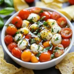 - 1 cup cherry tomatoes, halved - 1 cup fresh mozzarella balls (bocconcini), drained - 1/2 cup fresh basil leaves, chopped - 2 tablespoons balsamic glaze - 1 tablespoon olive oil - Salt and pepper to taste - Tortilla chips or sliced baguette, for serving This dip takes only 10 minutes to make. It serves 4 to 6 people. You can whip it up fast for any gathering. Each serving has about 150 calories. It is low in carbs and high in flavor. The fresh ingredients provide vitamins and minerals. The mozzarella adds protein and calcium, while the basil gives you antioxidants. Enjoy this dip without the guilt! {{ingredient_image_1}} To start, grab a mixing bowl. In it, combine 1 cup of halved cherry tomatoes and 1 cup of fresh mozzarella balls. The mozzarella should be drained well. Next, add in 1/2 cup of chopped fresh basil leaves. This adds a bright flavor. Drizzle 1 tablespoon of olive oil and 2 tablespoons of balsamic glaze over the mix. Then, sprinkle salt and pepper to taste. Now, gently toss everything together. You want the tomatoes, mozzarella, and basil to be evenly coated. This takes just a minute or two. Once mixed, transfer the dip to a serving dish. Spread it out evenly. For a finishing touch, drizzle some extra balsamic glaze on top. This will make it look fancy and appetizing. Caprese dip is perfect for sharing. I love serving it with tortilla chips. You can also use slices of baguette for dipping. Both options work well. Consider pairing the dip with a fresh salad or a meat dish. This makes for a balanced meal. It’s great for parties, snacks, or family dinners. When it comes to presentation, keep it simple but elegant. Use a nice serving bowl that shows off the colors. The red tomatoes, white cheese, and green basil look great together. You can garnish with a few whole basil leaves on top. This adds a pop of color. For an extra touch, place a small bowl of balsamic glaze next to the dip. This gives guests the option to add more if they like. You can swap cherry tomatoes for diced Roma tomatoes. This gives a different texture. Fresh mozzarella can be replaced with shredded mozzarella. Use what you have on hand. If you want less fat, try low-fat mozzarella. Fresh basil adds great taste, but you can use dried basil in a pinch. Just use less, as it's stronger. To boost flavor, add minced garlic for a zesty kick. A sprinkle of crushed red pepper adds heat. You can mix in some olives for a briny twist. Try adding a dash of lemon juice for brightness. If you like sweetness, use honey with the balsamic glaze. This will balance the flavors well. Store any leftover dip in an airtight container. It keeps well in the fridge for up to three days. When you’re ready to eat, no need to heat it. Just serve it cold. If you prefer it warm, place it in the oven at 350°F (175°C) for about 10 minutes. Keep an eye on it so it doesn’t get too hot. Enjoy! Pro Tips Use Fresh Ingredients: The quality of tomatoes and mozzarella can significantly enhance the flavor of your dip, so opt for the freshest ingredients possible. Chill Before Serving: Allow the dip to sit in the refrigerator for about 30 minutes before serving to let the flavors meld together beautifully. Experiment with Dipping Options: Try serving with homemade crostini or pita chips for a twist, or even fresh vegetable sticks for a healthier option. Add a Kick: For a spicy version, consider adding a pinch of red pepper flakes or diced jalapeños to the mix for an extra layer of flavor. {{image_2}} For a Mediterranean twist, add Kalamata olives and feta cheese. The salty olives and creamy feta enhance the dip's flavor. Mix in a little lemon juice for brightness. You can still use cherry tomatoes and mozzarella. This version gives a nice balance of salty and fresh tastes. If you like heat, try a spicy Caprese dip. Add diced jalapeños or crushed red pepper flakes. These ingredients bring a kick to the dish. You can mix in some spicy Italian sausage for more flavor. This version pairs well with cool drinks and adds excitement to any gathering. To make a vegan version, swap the mozzarella for vegan cheese. You can also use avocado for creaminess. Replace the balsamic glaze with a splash of balsamic vinegar. This keeps the taste bright and fresh. Add a touch of garlic for extra flavor. This dip is perfect for plant-based diets and still tastes amazing. You can serve Caprese dip with many tasty options. I love using tortilla chips. They add a nice crunch. Sliced baguette is also great. The bread soaks up the dip well. You can even use crackers for a different twist. Choose what you like best! Garnishing makes your dip look nice. I suggest adding more fresh basil leaves on top. This adds color and fresh flavor. A drizzle of balsamic glaze can make it shine. You can also sprinkle some salt and pepper to enhance the taste. These small touches make a big difference! Caprese dip fits many events. It’s perfect for parties and game days. Serve it at family gatherings or picnics. It’s quick to make, so it’s great for last-minute guests. I often bring it to potlucks. Everyone loves it! You can't go wrong with this dip at any occasion. Yes, you can make Caprese dip ahead of time. I recommend mixing the dip and storing it in the fridge. This keeps it fresh for up to two hours before serving. If you wait longer, the tomatoes may lose their crunch. To keep the dip bright, add the balsamic glaze right before serving. If you don’t have fresh basil, you can use dried basil. Use one teaspoon of dried basil for each tablespoon of fresh. You can also try fresh parsley or arugula for a different flavor. These herbs will change the taste but still make a nice dip. Caprese dip lasts about three days in the fridge. Make sure to store it in an airtight container. If you see any liquid at the bottom, drain it before serving again. The dip might lose some flavor, but it still tastes good when chilled. You now have a clear guide to making an easy Caprese dip. We covered ingredients, prep time, and health facts. I shared step-by-step instructions for mixing, serving, and presenting your dip. You learned how to enhance flavors and store leftovers. Variations like Mediterranean, spicy, and vegan styles keep it fun. Finally, I suggested great serving ideas and answered your common questions. Enjoy trying this simple recipe at your next gathering. Your guests will love it!