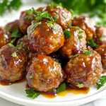 - 1 lb ground beef or turkey - 1/2 cup breadcrumbs - 1/4 cup grated Parmesan cheese - 1/4 cup chopped fresh parsley - 1 egg, beaten - 2 cloves garlic, minced - 1 tsp onion powder - 1/2 tsp salt - 1/2 tsp black pepper For the meatball base, you want to start with high-quality ground meat. I prefer ground turkey for a leaner option, but beef adds rich flavor. The breadcrumbs help bind everything together while keeping the meatballs tender. Parmesan cheese gives a nice salty kick. Fresh parsley brightens the dish, while garlic and onion powder add depth. The beaten egg helps hold the meatballs together. Season with salt and pepper for taste. - 1 cup cranberry sauce (preferably homemade or low-sugar) - 1/4 cup barbecue sauce - 1 tbsp soy sauce - 1 tsp ginger powder The glaze is where the magic happens. I recommend homemade cranberry sauce for the best flavor. Mix it with barbecue sauce for sweetness and depth. Soy sauce adds umami, while ginger powder gives a warm spice. This blend creates a sweet and savory glaze that perfectly coats the meatballs. - Extra chopped parsley - A drizzle of cranberry glaze To make your dish look festive, add extra chopped parsley on top of the meatballs. A drizzle of extra glaze adds a beautiful shine. These simple garnishes enhance the visual appeal and make your holiday table inviting. {{ingredient_image_1}} To start, gather all your ingredients. You will need ground beef or turkey, breadcrumbs, Parmesan cheese, fresh parsley, an egg, garlic, onion powder, salt, and black pepper. In a large mixing bowl, mix these items together. Use your hands to combine them well. Shape this mixture into small meatballs, about 1 to 1.5 inches wide. Place them on a baking sheet lined with parchment paper. Next, preheat your oven to 350°F (175°C). Once ready, bake the meatballs for 20 to 25 minutes. They should turn brown and be cooked through. Keep an eye on them to ensure they don’t overcook. The smell of baking meatballs will fill your kitchen! While the meatballs bake, it's time to make the glaze. In a medium saucepan, combine cranberry sauce, barbecue sauce, soy sauce, and ginger powder. Set the heat to medium and stir until the mixture is smooth and warm. This glaze adds a sweet and tangy flavor to your meatballs. Once the meatballs are done baking, take them out of the oven. Gently transfer the meatballs into the saucepan with the glaze. Toss them carefully to coat each meatball evenly. Let them simmer in the glaze for about 5 more minutes. This step helps the meatballs soak up all the delicious flavors. Serve them warm as an appetizer or over rice for a tasty main dish. To keep your meatballs juicy, use a mix of beef or turkey. The beef gives flavor, while turkey keeps them light. Add breadcrumbs and cheese for texture. The egg acts as a binder, so don’t skip it. Mix gently; overmixing can make them tough. The glaze is key for flavor. Use homemade cranberry sauce if you can; it's fresher. Mix it with barbecue sauce and soy sauce for a sweet and tangy taste. Heat it gently on the stove. If it’s too thick, add a little water. If it’s too thin, cook it longer to thicken. For a beautiful presentation, use a festive serving dish. After coating the meatballs in glaze, place them neatly. Drizzle some extra glaze on top for shine. Sprinkle chopped parsley for color. This small touch makes a big difference on your table! Pro Tips Use Fresh Ingredients: Fresh herbs and spices will enhance the flavor of your meatballs significantly. Opt for freshly chopped parsley and freshly minced garlic for the best results. Experiment with Glaze: Feel free to customize the glaze by adding a splash of orange juice or a hint of cinnamon for a unique twist on the cranberry flavor. Keep Meatballs Moist: If you find the mixture too dry, add a splash of milk or a bit more egg to keep the meatballs moist and tender while baking. Make Ahead: Prepare the meatballs in advance and store them in the refrigerator or freezer. Simply bake and glaze them when you're ready to serve! {{image_2}} You can switch up the meat in your meatballs. Ground turkey is a great option. It makes the dish leaner. You can also use chicken or even pork. Each protein brings a unique flavor. Adjust the cooking time slightly if needed. The glaze adds fun and flavor. Instead of cranberry sauce, try using peach or apricot. These fruits create a sweet twist. You can mix in some chili sauce for a spicy kick. A teriyaki glaze also works well. Experiment with different flavors to find your favorite. If you like heat, add some crushed red pepper. Mix it into the meatball mix for a spicy bite. You can also sprinkle cayenne pepper into the glaze. If you want a milder heat, try jalapeños. Just chop them finely and mix them in. Spice adds a new layer of flavor. After you make the meatballs, let them cool. Place them in an airtight container. They last in the fridge for 3 to 4 days. If you have extra glaze, store it separately. This keeps the meatballs from getting soggy. To freeze, first cool the meatballs completely. Arrange them in a single layer on a baking sheet. Freeze them for about an hour. Once they are firm, transfer them to a freezer bag. They can last up to 3 months in the freezer. Remember to label your bags with the date. To reheat, you can use the oven or microwave. For the oven, heat to 350°F (175°C) and bake for about 15 minutes. If using a microwave, place the meatballs on a microwave-safe plate. Heat for about 1 to 2 minutes, checking often. If you want, add a little extra glaze before reheating. This keeps them juicy and flavorful. Yes, you can use frozen meatballs. They save time and still taste good. Just bake them according to the package directions. After baking, coat them in the cranberry glaze. This way, you keep the flavors rich. Cranberry meatballs shine on their own. You can serve them as an appetizer. They also work well over rice for a main dish. Pair them with a fresh salad or roasted vegetables for color and balance. You can store leftover meatballs in the fridge for about three days. Keep them in an airtight container. For longer storage, freeze them for up to three months. Just thaw before reheating. Yes, you can make this dish ahead. Prepare the meatballs and glaze in advance. Store them separately in the fridge. When ready to serve, bake the meatballs and combine them with the glaze. This keeps everything fresh and tasty. In this post, we explored making cranberry meatballs, covering ingredients, steps, and tips. We discussed how to mix meatball bases, create the glaze, and add personal touches. Remember, moist meatballs and a great glaze can really make a dish shine. Feel free to try different proteins and sauces for variety. Store leftovers easily in the fridge or freezer. Now, you can enjoy this tasty meal anytime you want. Happy cooking!