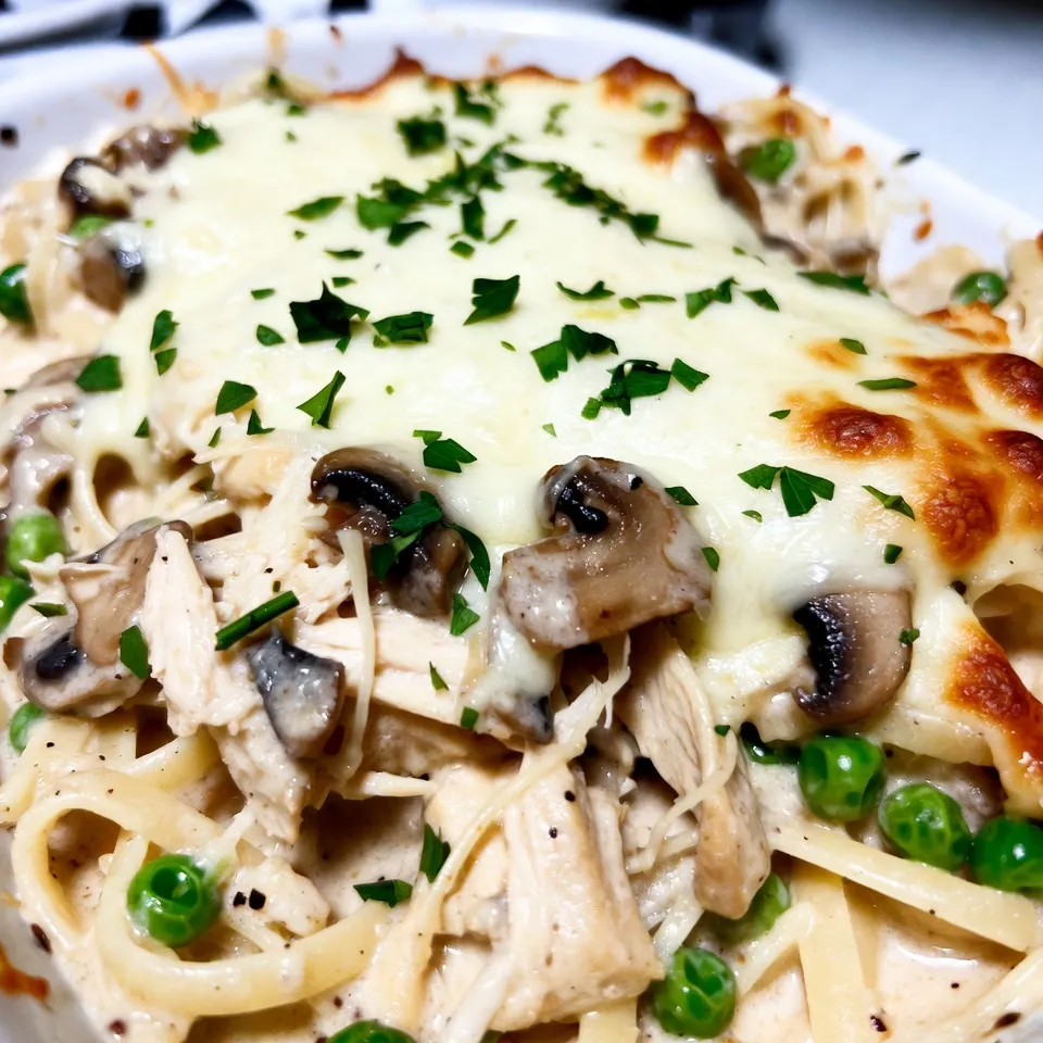- 8 ounces of linguine or spaghetti - 2 cups of cooked chicken, shredded - 1 cup sliced mushrooms - 1 cup frozen peas - 1 small onion, diced - 2 cloves garlic, minced - 1 teaspoon dried thyme - 1 teaspoon garlic powder - Salt and pepper to taste - 4 tablespoons butter - 4 tablespoons all-purpose flour - 2 cups chicken broth - 1 cup heavy cream - 1 cup grated Parmesan cheese - 1 cup shredded mozzarella cheese - Fresh parsley, chopped for garnish (optional) This recipe for creamy chicken tetrazzini uses simple, tasty ingredients. The main stars are the pasta and chicken. You can use linguine or spaghetti, whichever you prefer. The cooked chicken adds protein and is easy to shred. Next, we have our vegetables and seasonings. The mushrooms give a nice earthy flavor, while peas add sweetness. Onions and garlic bring a lovely aroma. Thyme and garlic powder enhance the taste. Don't forget salt and pepper; they bring all the flavors together. For the creamy sauce, we use butter and flour to make a roux. This thickens our sauce perfectly. Chicken broth adds depth, while heavy cream makes it rich. Finally, the cheeses are what make this dish so special. Parmesan gives a salty kick, and mozzarella adds gooeyness. If you want, sprinkle fresh parsley on top for a pop of color. With these ingredients, you will create a dish that is both hearty and comforting. Now, let's get cooking! {{ingredient_image_1}} - Boil salted water in a large pot. - Add 8 ounces of linguine or spaghetti. - Cook according to package instructions until al dente. - Drain and set aside. - Melt 4 tablespoons of butter in a skillet over medium heat. - Add 1 small diced onion, 2 minced garlic cloves, and 1 cup of sliced mushrooms. - Sauté until the vegetables are tender, about 5-7 minutes. - Stir in 4 tablespoons of all-purpose flour with the cooked vegetables. - Gradually add 2 cups of chicken broth while whisking. - Whisk until the mixture thickens, about 3-5 minutes. - Add 1 cup of heavy cream, 1 teaspoon dried thyme, 1 teaspoon garlic powder, salt, and pepper. - Add 2 cups of shredded chicken and 1 cup of frozen peas to the skillet. - Stir well to coat everything in the creamy sauce. - Cook for an additional 2-3 minutes until heated through. - Preheat your oven to 350°F (175°C). - Transfer the mixture to a greased 9x13 inch baking dish. - Top with 1 cup of grated Parmesan and 1 cup of shredded mozzarella. - Bake in the oven for 25-30 minutes. - Remove when the cheese is bubbly and golden brown. - Let sit for a few minutes before serving. - Garnish with fresh parsley, if desired. How to prevent lumps in the sauce? To prevent lumps, stir the flour into the sautéed vegetables first. This helps it blend well. Gradually pour in the chicken broth while whisking. Keep whisking until the sauce thickens. Adjusting seasoning to taste Taste the sauce as you cook. Adjust the salt and pepper based on your preference. If it needs more flavor, add extra thyme or garlic powder. Always remember, you can add but not take away! Best practices for al dente pasta Cook your pasta in boiling salted water. Follow the package instructions but check it one minute early. Al dente means it should be firm but not hard. Drain it right away to stop the cooking. Alternatives for gluten-free options For a gluten-free dish, use gluten-free pasta. Cook it just like regular pasta. You can also try zucchini noodles for a low-carb option. They add a fresh taste too! Recommended cheese varieties for richer flavor Use a mix of cheeses for depth. Parmesan adds a nutty taste, while mozzarella gives creaminess. You might also try gouda or cheddar for a twist. How to achieve a crispy topping To get a crispy topping, sprinkle extra cheese before baking. You can also add breadcrumbs mixed with a bit of melted butter. Bake until golden brown for that perfect crunch! Pro Tips Cook Pasta Al Dente: Ensure the pasta is cooked al dente for the best texture. It will continue to cook in the oven, preventing it from becoming mushy. Use Rotisserie Chicken: For a quicker preparation, use store-bought rotisserie chicken. It’s convenient and adds great flavor to the dish. Customize the Veggies: Feel free to add or swap vegetables like bell peppers or spinach based on your preferences or what you have on hand. Don’t Skip the Cheese: The combination of Parmesan and mozzarella creates a deliciously cheesy topping. Be generous for a golden, bubbly finish! {{image_2}} You can switch up the protein in your tetrazzini. Using rotisserie chicken saves time. It’s already cooked and adds great flavor. Just shred it and mix it in. Homemade chicken works too, but takes longer. For a vegetarian twist, use mushrooms or tofu. Sauté the mushrooms until they are nicely browned. If you use tofu, press it first to remove water. Then, cut it into cubes and sauté until golden. Both options give great taste and texture. Adding seasonal veggies can boost the flavor. Think about using asparagus in spring or zucchini in summer. They add color and nutrients. You can also toss in fresh spinach or bell peppers. Just sauté them with the onions and garlic for a tasty mix. To make your dish pop, add spices or herbs. A pinch of cayenne pepper can add warmth. Fresh herbs like basil or parsley can brighten the dish. Experiment with cheese too. Try gouda for a smoky flavor or cheddar for sharpness. Mixing different cheeses can make your tetrazzini unique and delicious. Store your leftover creamy chicken tetrazzini in an airtight container. Make sure it cools down first. This dish will last about 3 to 4 days in the fridge. Always check for any off smells before eating. To freeze tetrazzini, use a freezer-safe container. Let it cool completely before sealing. It keeps well for up to 3 months. For best results, freeze in individual portions. When you're ready to eat, thaw it overnight in the fridge. Reheat in the oven at 350°F (175°C) until heated through. You can also use the microwave, but the oven makes it taste better. Pair your creamy chicken tetrazzini with a fresh salad or garlic bread. A side of steamed veggies also works well. To reheat, cover with foil to keep it moist. Bake for 20 minutes, then remove the cover for a crispy top. Enjoy your meal! Yes, you can! Here are some great options: - Penne: This shape holds sauce well. - Fusilli: Its twists capture the creamy sauce nicely. - Gluten-free pasta: Perfect for those with gluten issues. - Egg noodles: They add a nice texture. Feel free to experiment with your favorite pasta. Each type changes the dish a bit, but they all work! Making this dish ahead is simple. Just follow these steps: 1. Prepare the pasta and sauce as directed. 2. Combine all ingredients in your baking dish. 3. Cover it tightly with plastic wrap or foil. 4. Store it in the fridge for up to 24 hours. When ready, just bake it straight from the fridge. You may need to add a few extra minutes to the baking time. If you want to swap heavy cream, here are some options: - Coconut milk: For a dairy-free twist, it adds a nice flavor. - Half-and-half: A lighter choice that still adds creaminess. - Greek yogurt: This gives a nice tang and is lower in fat. Adjust the amount based on how creamy you want your dish. Leftover tetrazzini can last in the fridge for about 3-4 days. To store it: - Place it in an airtight container. - Keep it cool in the fridge. If you want to enjoy it later, you can freeze it for up to 2-3 months. Just thaw it overnight before reheating. Absolutely! Here are some tips to make it more appealing: - Use fun pasta shapes like stars or shells. - Cut the chicken into smaller bites for easy eating. - Add a bit more cheese on top to make it extra cheesy. Kids usually love creamy dishes, and this one is no exception! This dish combines tasty pasta, chicken, and creamy sauce. You learned about key ingredients, cooking steps, and variations. The tips can help you avoid common mistakes and make it your own. Enjoying this dish is easy, whether for a family meal or a friendly gathering. Feel free to try different flavors and ingredients to suit your taste. With simple storage tips, you can enjoy leftovers for days. So get cooking and savor every bite!