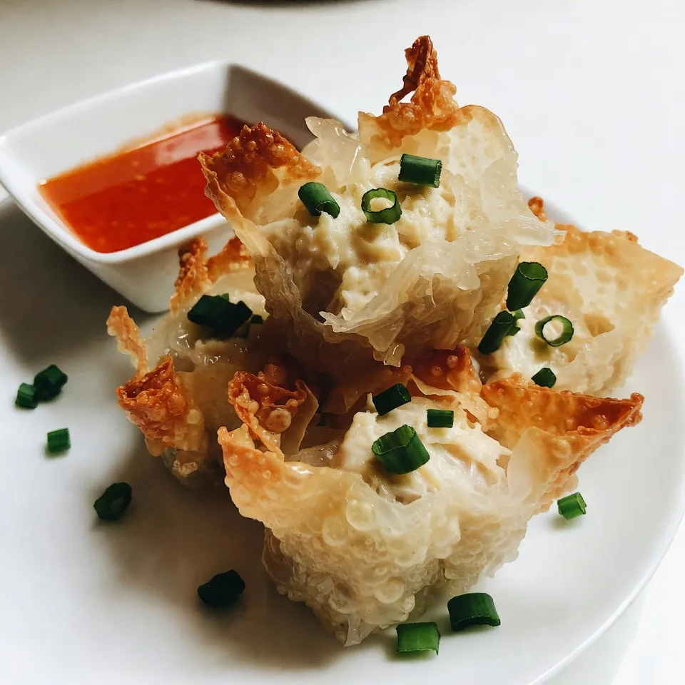 - 8 oz cream cheese, softened - 6 oz lump crab meat, drained and shredded - 2 green onions, finely chopped - 1 garlic clove, minced - 1 tsp Worcestershire sauce - 1 tsp soy sauce - 1/2 tsp garlic powder - 1/2 tsp onion powder - 10 sheets rice paper - Oil for frying For the best crab rangoons, you need fresh ingredients. The cream cheese brings a rich flavor. It blends well with the crab meat, making it creamy. Lump crab meat adds a sweet taste that shines through. Green onions add a fresh crunch, while garlic gives depth. The seasonings bring everything together. Worcestershire sauce gives a tangy kick. Soy sauce adds umami, while garlic and onion powders boost flavor. Rice paper is key for wrapping these rangoons. It crisps up perfectly when fried. You want to handle it gently to avoid tears. Heating oil is crucial for that golden brown color. Use enough oil to cover the rangoons halfway. This ensures even cooking and a perfect crunch. {{ingredient_image_1}} Start by combining the cream cheese and lump crab meat in a mixing bowl. Add in the finely chopped green onions and minced garlic. Then, pour in the Worcestershire sauce and soy sauce. Sprinkle in the garlic powder, onion powder, salt, and pepper. Mix everything together until it's creamy and smooth. You want the filling to be thick but easy to scoop. If it’s too thick, add a little more cream cheese to loosen it up. Next, you need to prepare the rice paper. Fill a shallow dish with warm water. Dip one sheet of rice paper into the water for about 10-15 seconds. The paper should become soft but not mushy. Carefully lift it out and lay it flat on a clean surface. Spoon about 1-2 tablespoons of the crab mixture onto the bottom third of the rice paper. Fold the sides over the filling, then roll tightly from the bottom up. Make sure you seal it well to keep the filling inside. Repeat this process with the remaining rice paper and crab mixture. Now it’s time to fry. Heat about 1 inch of oil in a deep skillet or frying pan over medium heat. Make sure the oil is hot before you add the rangoons. This helps them cook evenly and get crispy. Carefully place a few crab rangoons into the oil. Don’t overcrowd the pan. Fry for about 3-4 minutes, turning them occasionally. You want them golden brown and crispy. Once cooked, remove the rangoons with a slotted spoon. Drain them on paper towels to remove excess oil. Serve them warm with sweet chili sauce or your favorite dipping sauce. Enjoy your crispy rice paper crab rangoons! For the best crab meat, use lump crab. It has a sweet taste and great texture. Always drain it well before mixing. This helps keep your filling from being too wet. To enhance flavor, add a splash of fresh lemon juice. It brightens the dish and balances the creaminess of the cheese. You can also mix in some finely chopped cilantro for a fresh twist. To prevent tearing rice paper, soak it just until soft. About 10-15 seconds in warm water is enough. After soaking, lay it flat on a clean surface. If you want added strength, double-layer the rice paper. For wrapping, place the filling at the bottom third. Fold the sides over and roll tightly. This keeps everything secure inside. Heat your oil to about 350°F for frying. This is the sweet spot for crispy rangoons. Make sure not to overcrowd the pan when frying. This helps maintain the oil temperature. If you notice sogginess, drain the rangoons well on paper towels after frying. This step absorbs excess oil, ensuring a crispy finish. Pro Tips Prep Your Ingredients: Ensure all your ingredients are prepped and measured before starting. This will make the assembly process smoother. Keep the Rice Paper Moist: Work quickly with the rice paper to prevent it from drying out. If it gets too dry, it can become brittle and hard to work with. Oil Temperature Matters: Make sure your oil is hot enough before frying. A temperature of 350°F (175°C) is ideal for achieving crispy rangoons. Experiment with Fillings: Feel free to mix different seafood or vegetables into the filling for a unique twist on traditional crab rangoons. {{image_2}} You can easily switch some ingredients in your crab rangoons. If you want a vegan option, try using cashew cream instead of cream cheese. This will give you a rich texture without dairy. For protein, crab is great, but shrimp or chicken also works. Just make sure to cook them first. This way, you keep the filling safe and tasty. To spice things up, add sriracha or diced jalapeños to the crab mix. This gives your rangoons a nice kick. You can even adjust the amount based on your taste. Adding fresh herbs like cilantro or parsley can brighten the flavor too. Just chop them finely and mix them in. It makes every bite fresh and fun! When it comes to dipping sauces, sweet chili sauce is a classic choice. It pairs well with the creamy filling. You can also try soy sauce or a spicy mayo for extra flavor. For side dishes, consider serving with a light salad or crispy veggies. This adds color and crunch to your meal. Enjoy your crispy rice paper crab rangoons with these fun additions! To keep your fried crab rangoons fresh, store them in an airtight container. Place a paper towel in the container to absorb moisture. This helps maintain their crispness. Store them in the fridge for up to three days. When you want to eat them again, reheating is key. Preheat your oven to 375°F (190°C). Lay the rangoons on a baking sheet and heat for about 10-12 minutes. This method keeps them crispy. You can freeze crab rangoons before or after frying. If you freeze them before frying, lay them on a baking sheet. Make sure they do not touch each other. Once they are frozen solid, transfer them to a freezer bag. This helps prevent freezer burn. If you freeze them after frying, make sure they are completely cool. Then, store them in an airtight container or freezer bag. They can stay fresh for up to three months. To thaw frozen rangoons, place them in the fridge overnight. For cooking, preheat your oven to 375°F (190°C) and bake for 15-20 minutes. This will help them crisp up again. Enjoy your crispy treat! Crispy rice paper crab rangoons are a fun twist on a classic dish. They combine cream cheese and crab meat, wrapped in rice paper. The rice paper gives them a light and crunchy texture. Their appeal lies in the creamy filling and the crispy outside. Each bite offers a delicious mix of flavors. These rangoons are perfect for snacking or as a party treat. Yes, you can prepare them ahead of time. Make the crab filling and wrap the rangoons. Store them in the fridge for up to a day. Just remember to cover them to keep them moist. When you're ready, fry them straight from the fridge. This way, you can enjoy fresh, crispy rangoons without much fuss. Popular choices for dipping sauces include sweet chili sauce and soy sauce. These add a nice contrast to the creamy filling. You might also try a spicy mayo or a tangy ponzu sauce. Each sauce enhances the flavors and adds fun to your meal. Feel free to explore different sauces to find your favorite pairings. To achieve the best crispiness, keep these tips in mind: - Use rice paper that is fresh and pliable. - Heat the oil to the right temperature before frying. - Do not overcrowd the pan when frying. This helps them cook evenly. - Fry them until golden brown, about 3-4 minutes. - Drain on paper towels to remove excess oil. This keeps them crispy and light. In this blog post, we covered how to make delicious crab rangoons with rice paper. We explored essential ingredients like cream cheese and crab meat, along with seasonings and cooking methods. You learned tips for preparing the filling, wrapping techniques, and frying for perfect crispiness. Don't forget the variations and storage tips to enhance your experience. With these steps, you can enjoy tasty rangoons any time. Now, get cooking and impress your friends with this fun snack!